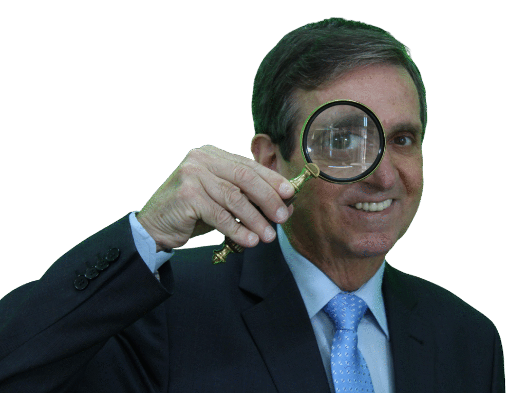 Itacir Flores com uma lupa, instrutor do curso de Detetive Particular.